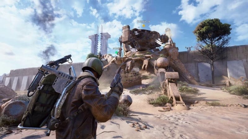 ARC Raiders gameplay screenshot showing a player aiming at a crashed robot structure in a desert combat zone.